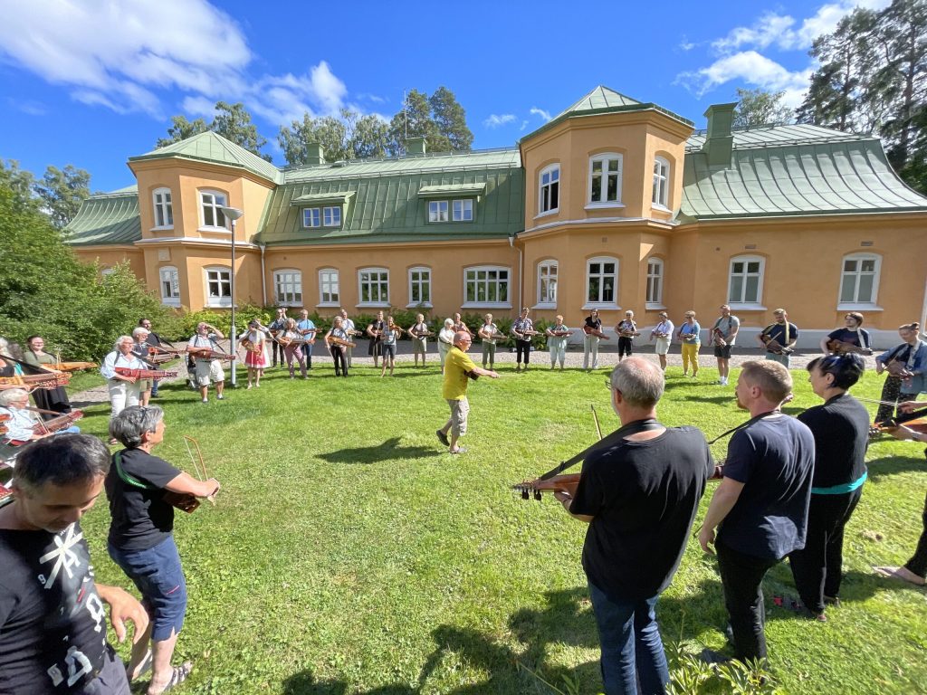 Muzykujący w kręgu grający na nyckelharpach w centrum Torbjorn Nasbom