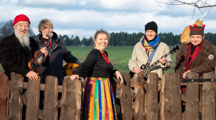 Orkiestra św. Mikołaja stoi przy płocie na tle lasu - portret